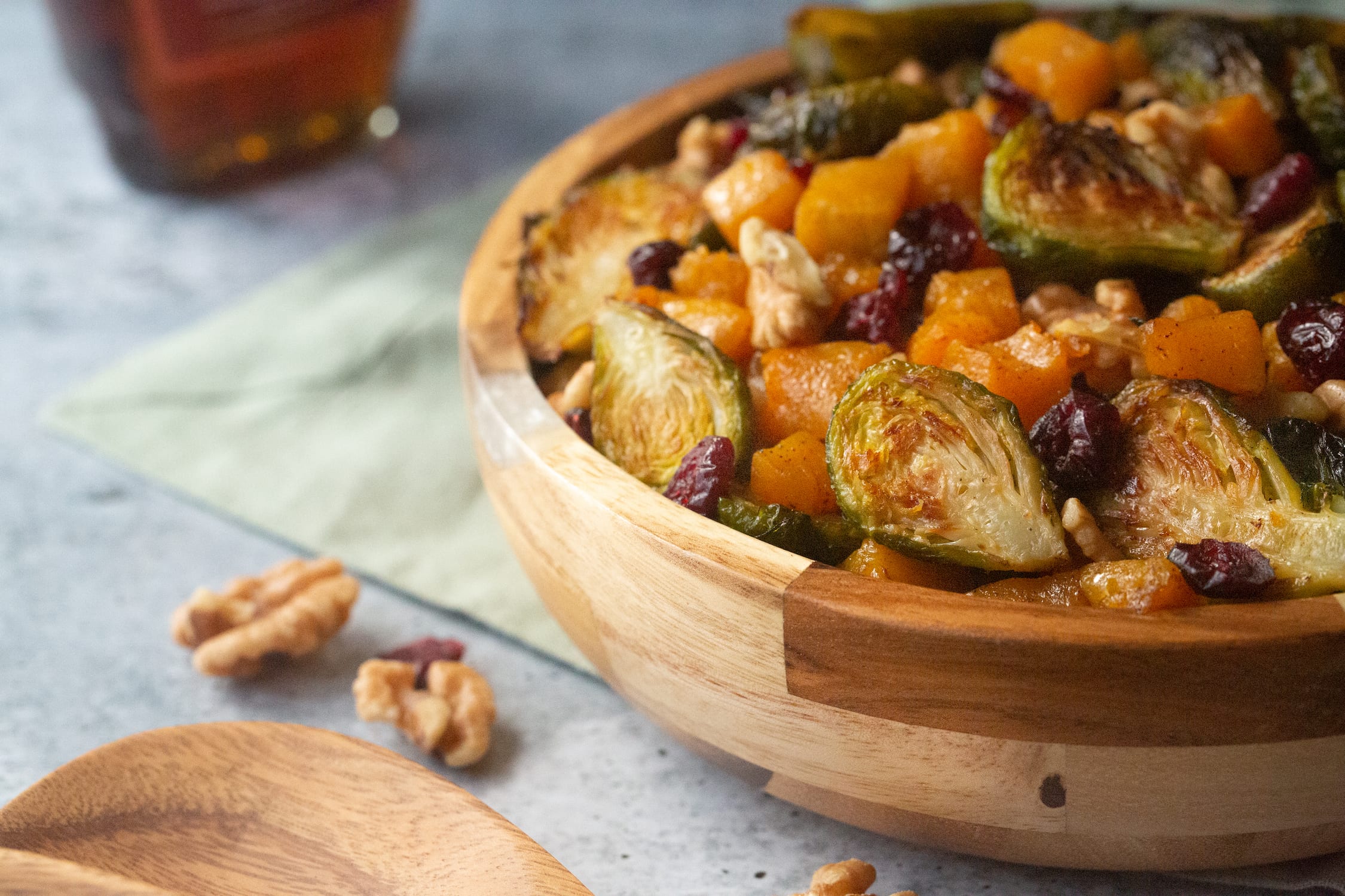 Brussels sprouts, sweet potato, cranberries and walnut in a bamboo serving bowl.
